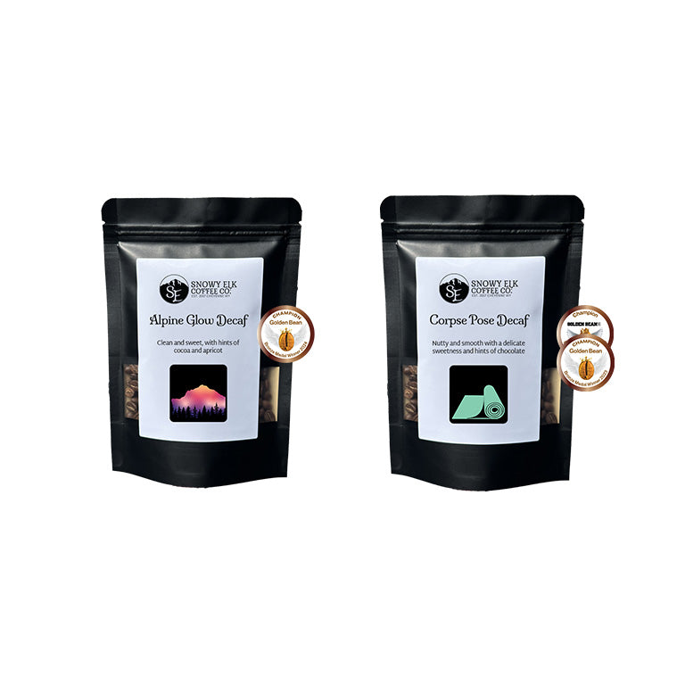 Two black coffee bags with labels that say Alpine Glow Decaf and Corpse Pose Decaf on a white background