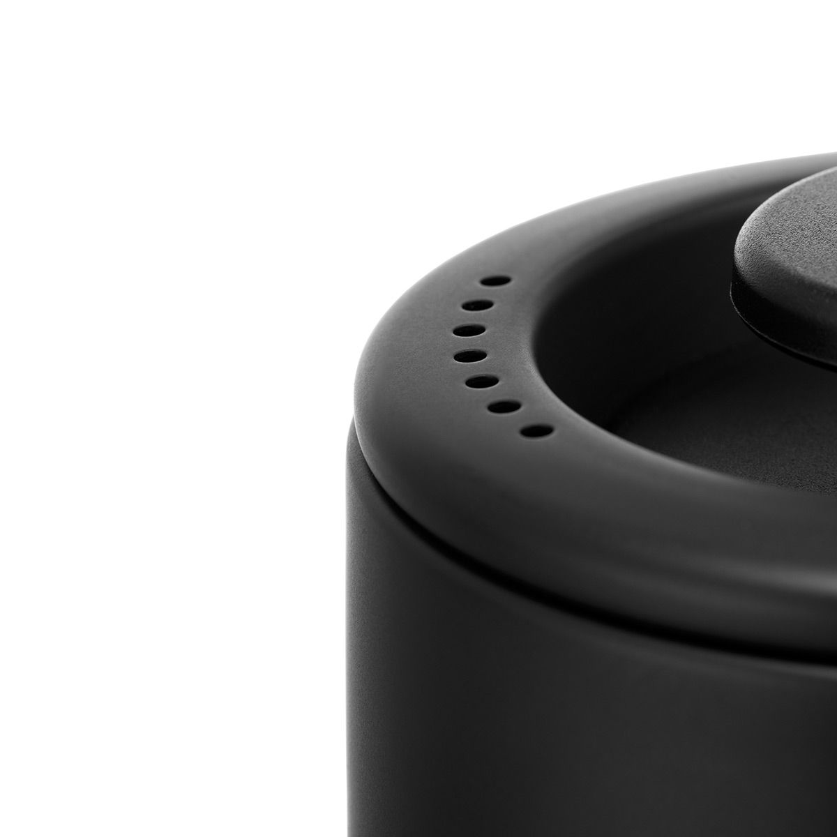 A black kettle lid with small holes around the edge on a white background A black kettle lid with small holes around the edge on a white background