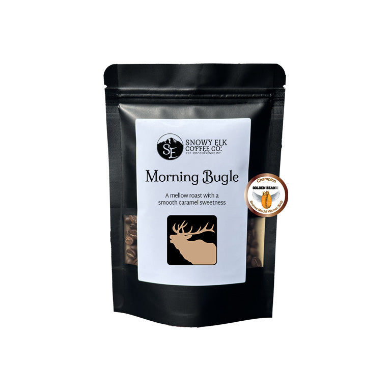 Black coffee bag with 'Snowy Elk Coffee Co.' branding and 'Morning Bugle' flavor description on a white background. Black coffee bag with 'Snowy Elk Coffee Co.' branding and 'Morning Bugle' flavor description on a white background.