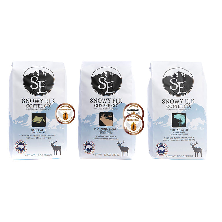Three bags of Snowy Elk coffee, featuring light, medium, and dark roast, arranged side by side against a white background. Three bags of Snowy Elk coffee, featuring light, medium, and dark roast, arranged side by side against a white background.