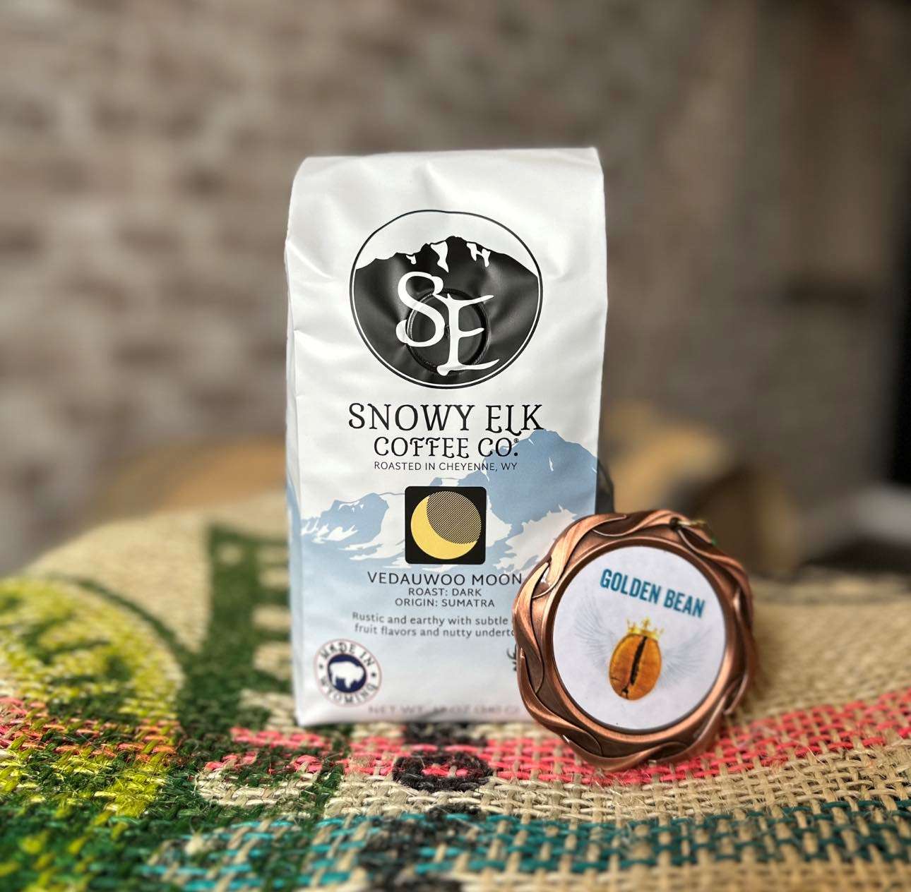 A bag of coffee named Vedauwoo Moon on an empty burlap bag with a medal leaning on it