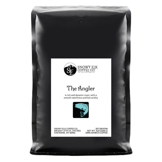 A bag of Snowy Elk Coffee Co. coffee beans labeled 'The Angler', indicating a single origin Colombian roast.