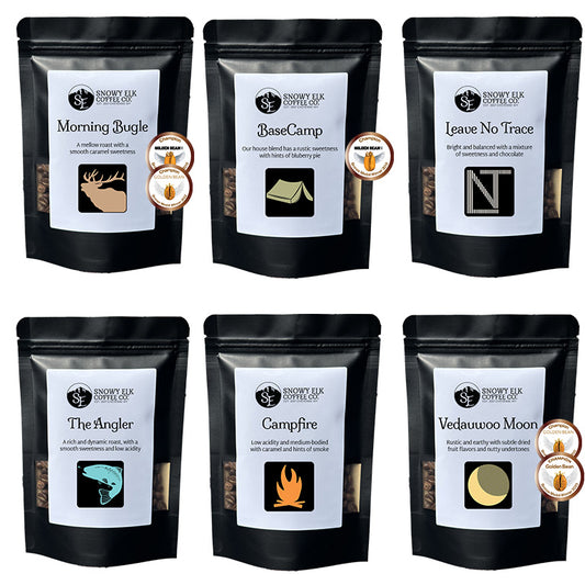 Six packages of Snowy Elk Coffee Co. coffee with labels and branding. Six packages of Snowy Elk Coffee Co. coffee with labels and branding.