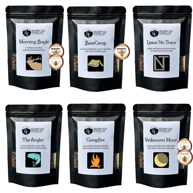 Six packages of Snowy Elk Coffee Co. coffee with labels and branding.