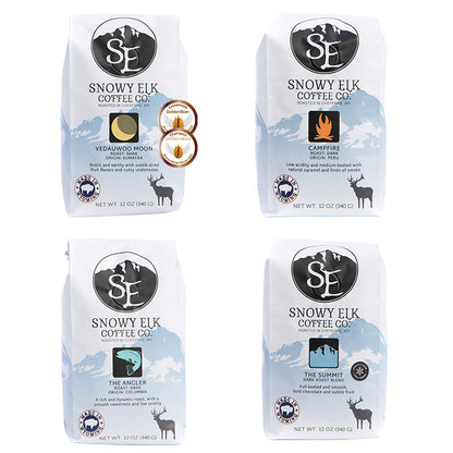 Four white and blue bags of dark roasted coffee with Snowy Elk branding 