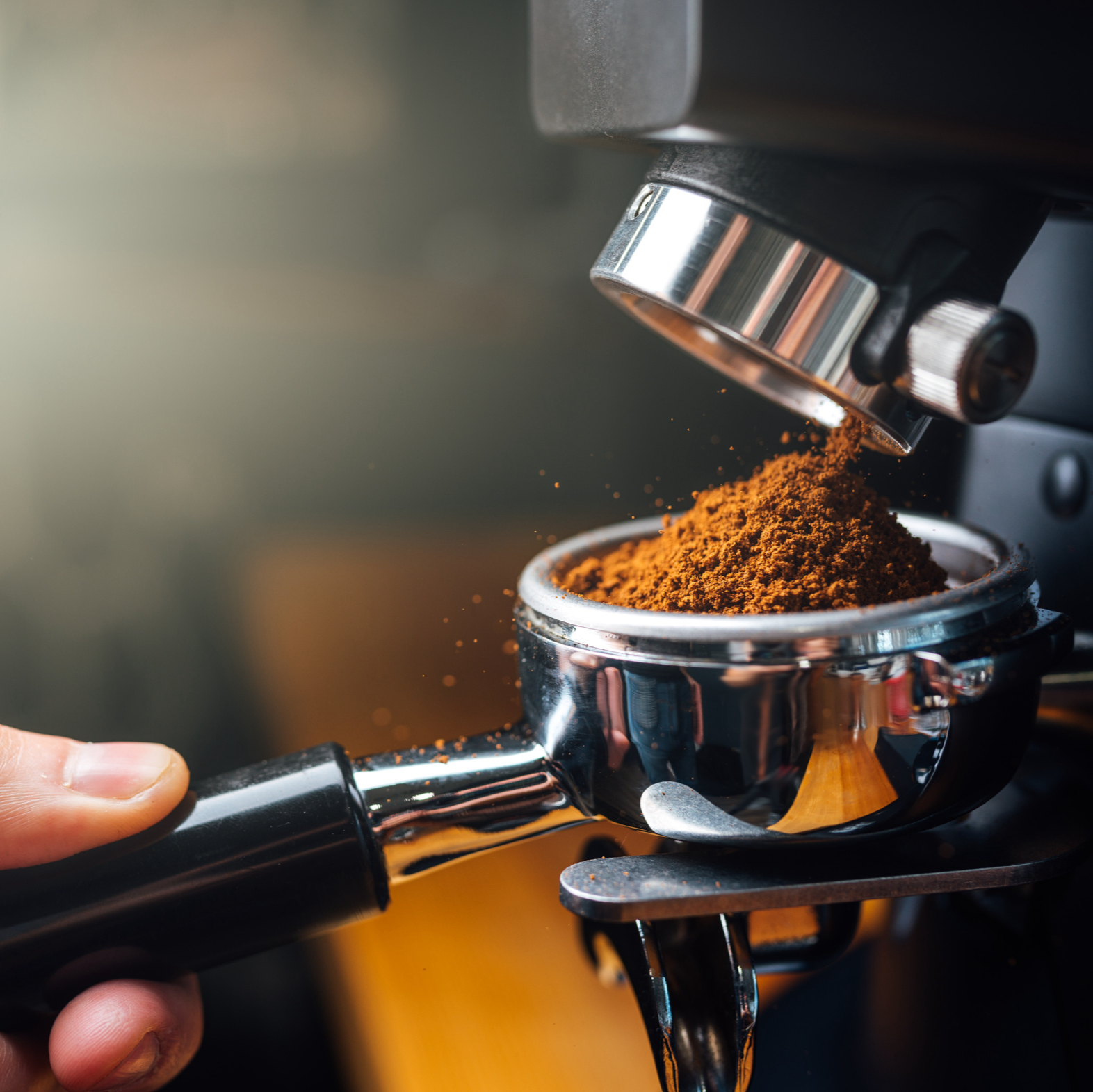 A close up of beans being ground into an espresso machine group head