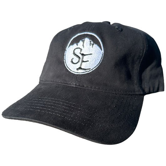 A black baseball cap with the Snowy Elk logo embroidered on the front. A black baseball cap with the Snowy Elk logo embroidered on the front.